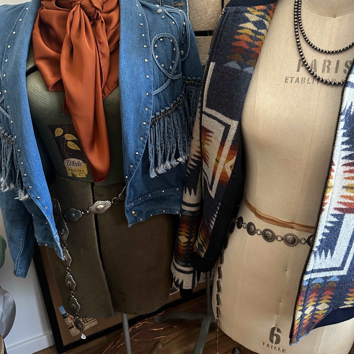 Nickel silver concho belts styled on two vintage dress forms.